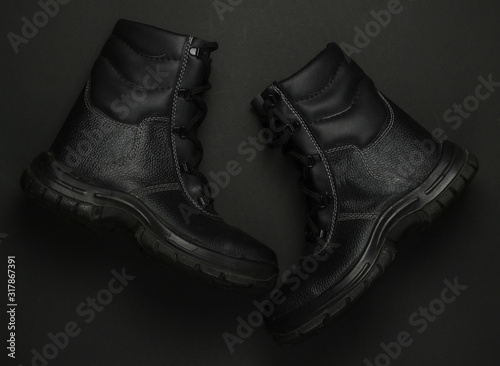 Work leather shoes on black background. Safety gear