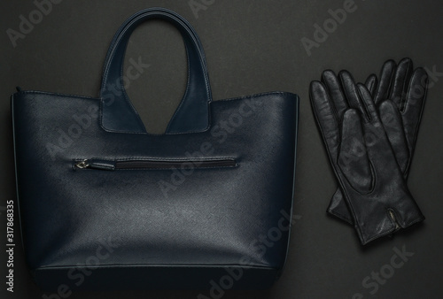 Women's fashion accessories on a black background. Lather bag, gloves. Top view