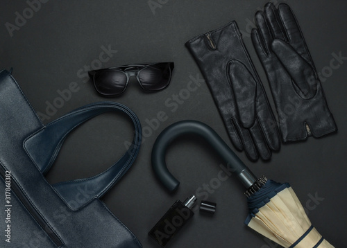 Women's fashion accessories on a black background. Lather bag, gloves, umbrella, sunglasses, perfume bottle. Top view