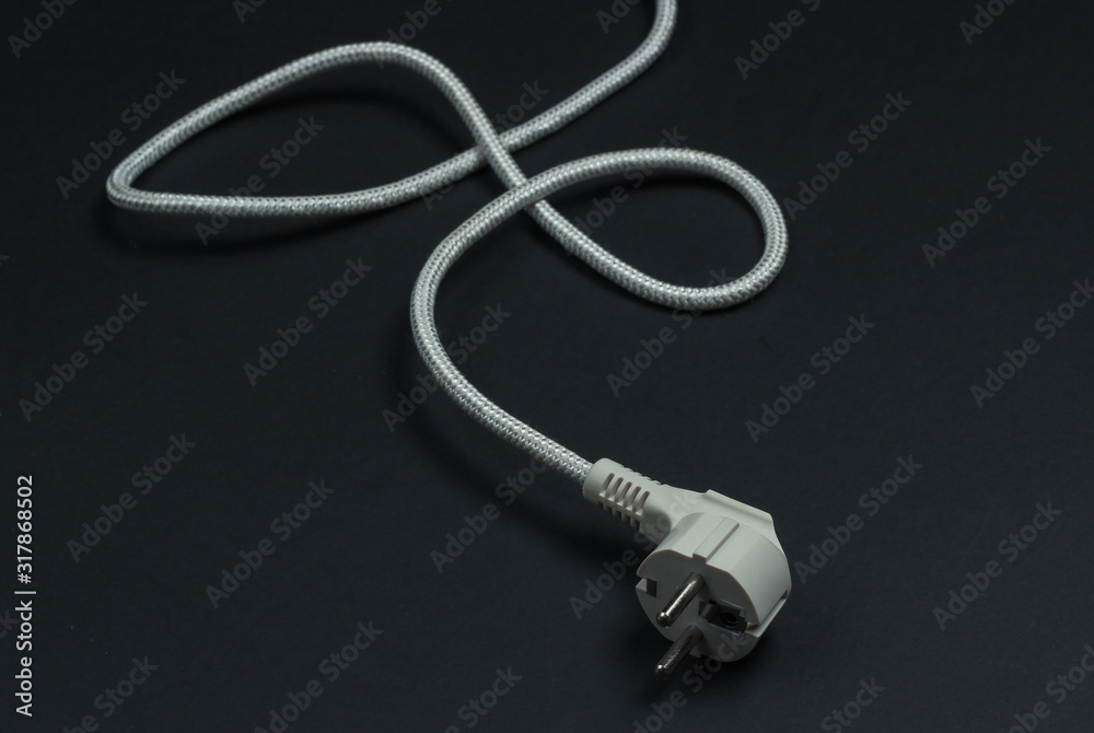Electric plug with cable on a black background close-up Electric plug with cable on a black background close-up