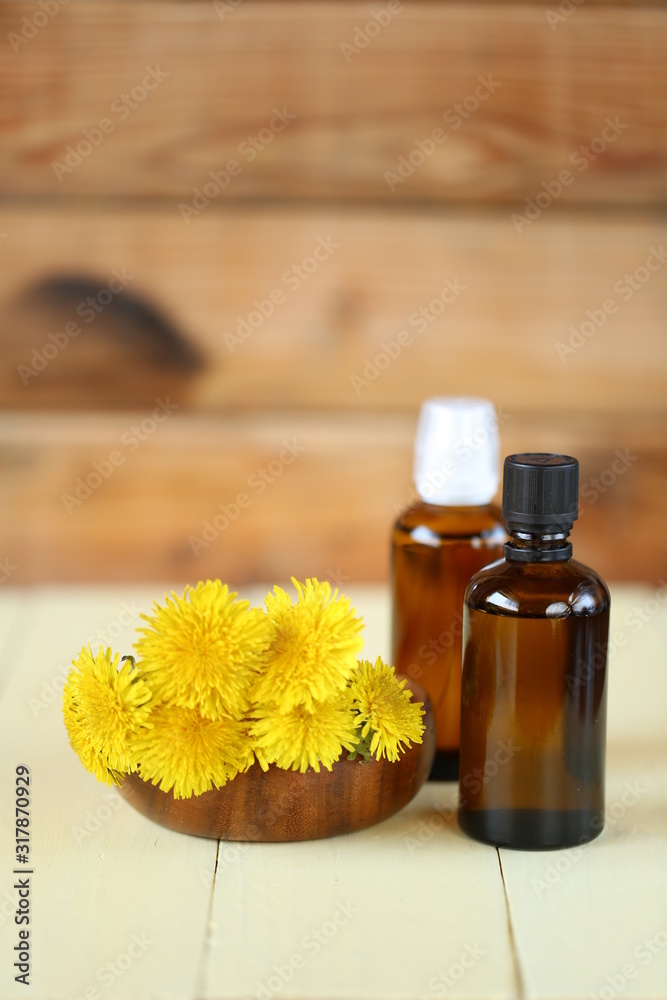Dandelion tincture. Herbal tincture.   Medicinal tincture in  glass bottles and dandelion flowers on a  wooden background.infusion of healing herbs. Homeopathy