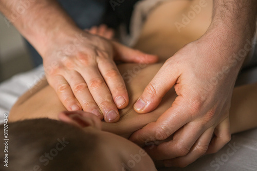 Boy toddler relaxes from a therapeutic massage. Physiotherapist working with patient in clinic to the back of a child