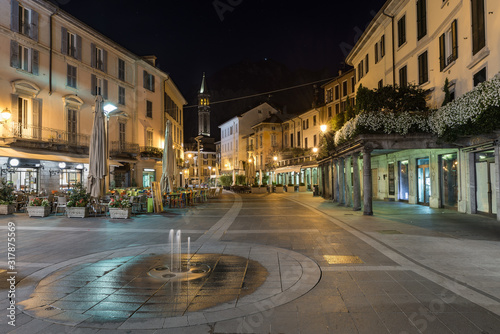 Downtown deserted city street scene at night. Lecco, Italy. Picturesque town overlooking lake Como. Square XX Settembre near the old Viscontea tower