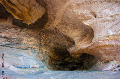 A deep light wide cave becomes dark and narrow. Sandstone Caves, Pilliga National Park, NSW, Australia.