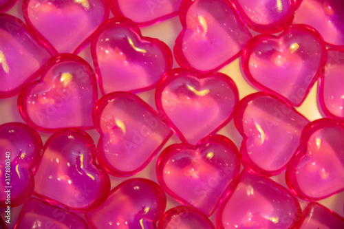 Background of pink, glass hearts on a white background. The concept of Valentine's Day, background, texture.