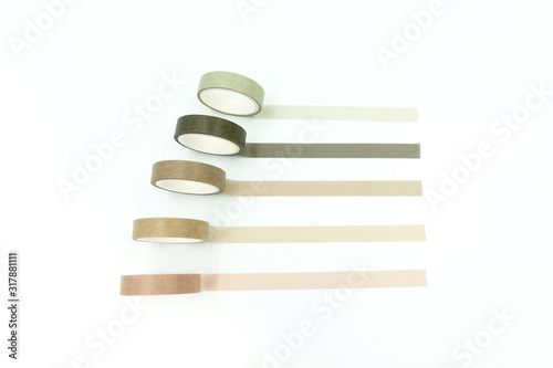 Close up top view of paper masking tape in set of green arranging in a row and taping on board. Isolated on white background with copy space.