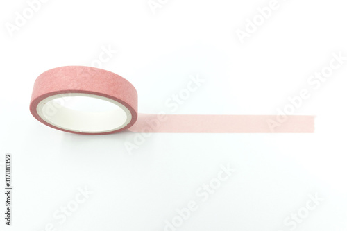 Close up side view of paper masking tape in green and pink sets stacking up in a roll isolated on white background with copy space.