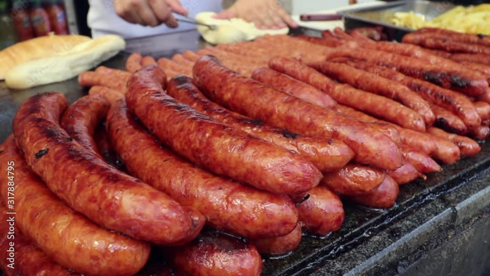 Slow sliding shot of sausages and buns being prepped by a street vendor Slow sliding shot of sausages and buns being prepped by a street vendor