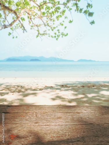 Empty wooden with tree and tropical beach background. © TongTa