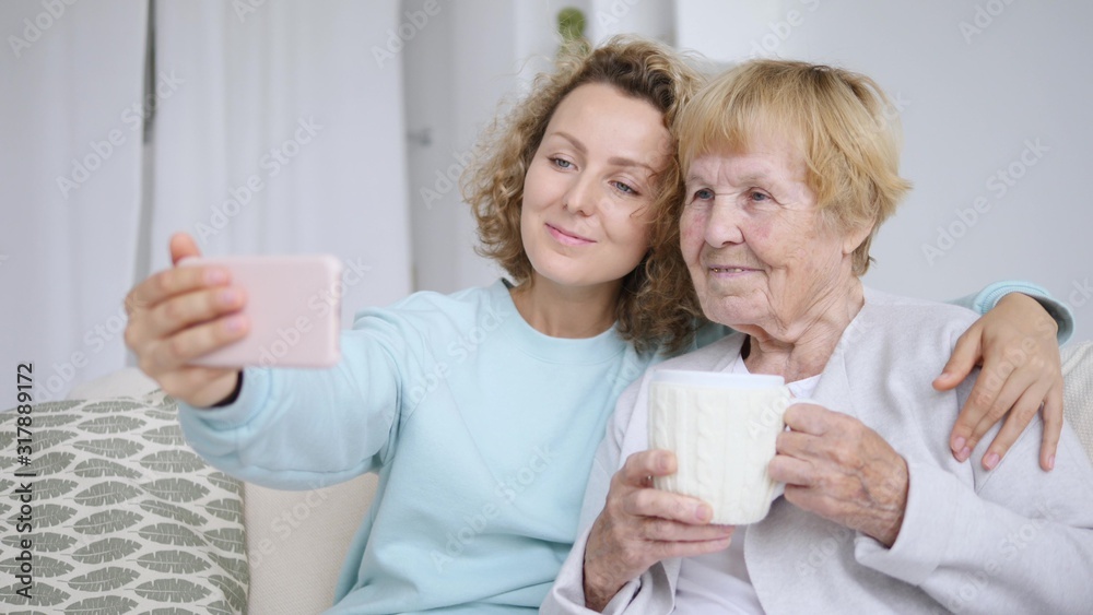 Close-Up Portrait Of Joyful Happy Elderly Grandmother Taking Selfie With Granddaughter Close-Up Portrait Of Joyful Happy Elderly Grandmother Taking Selfie With Granddaughter