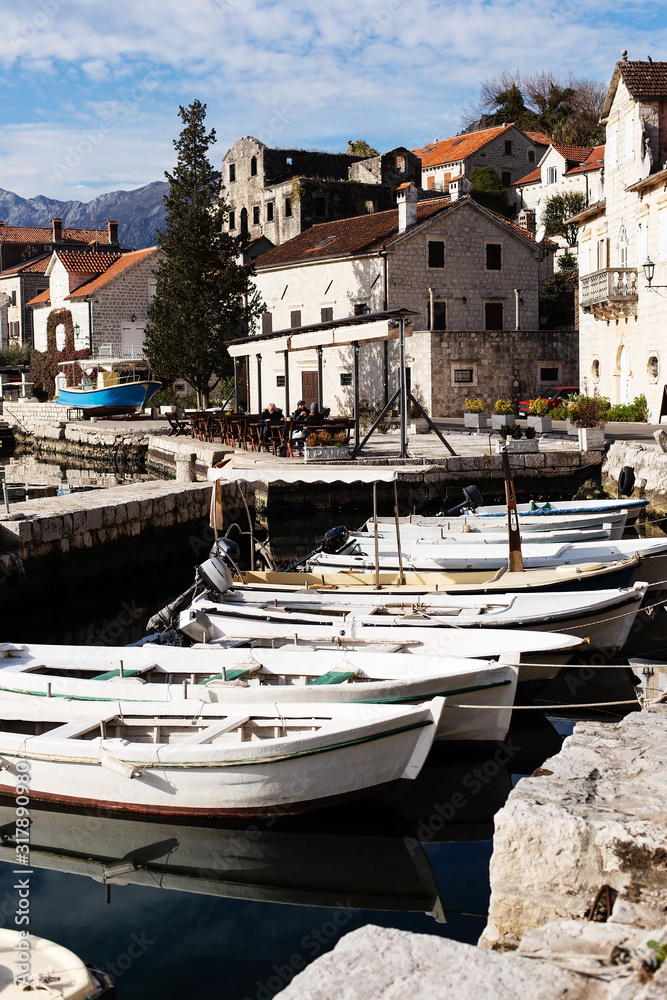 boats at the pier on the shore of the city of Perast