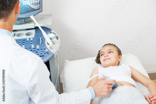 Doctor ultrasound examines little girl belly