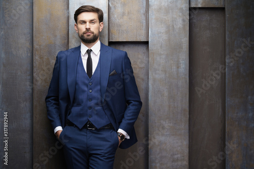 indoor photo of young handsome stylish businessman wearing suit photo