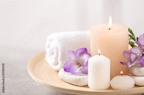 Beautiful composition with spa stones and burning candles on grey table