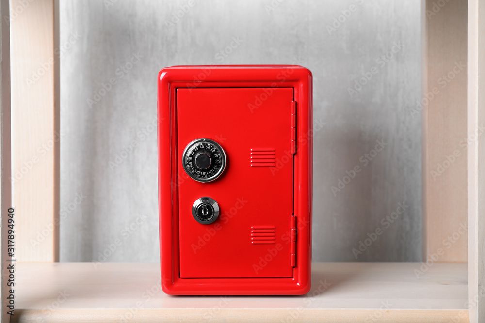 Red steel safe with mechanical combination lock on shelf Red steel safe with mechanical combination lock on shelf