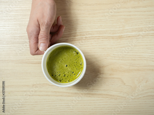 Woman drinking matcha tea, on the kitchen