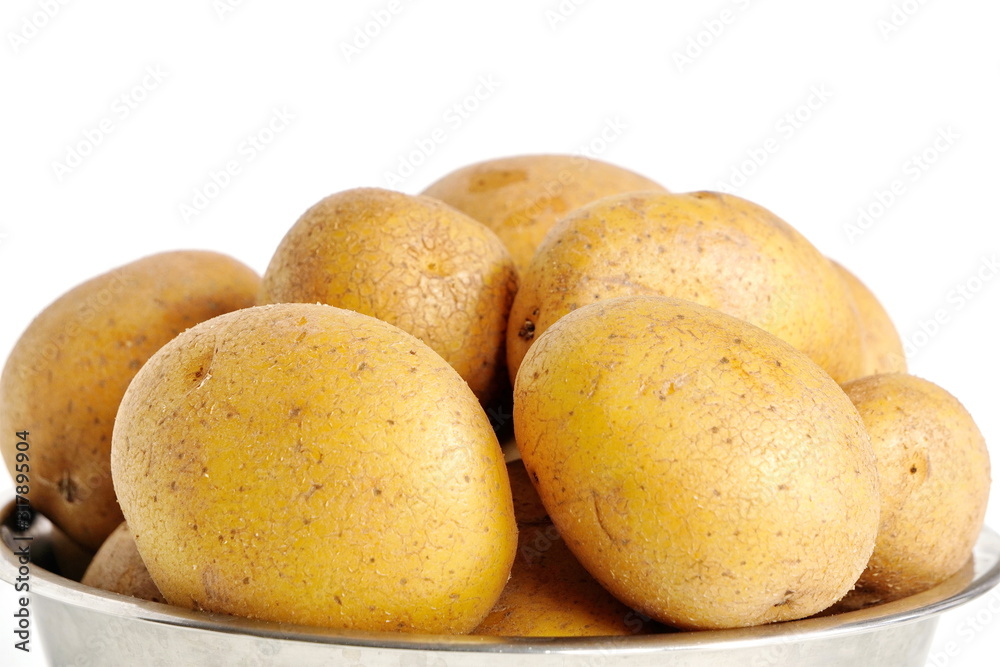 Untreated unpeeled organic fresh raw potatoes in their skins in a metal plate or pan on a white background. vegetable dishes, healthy food. Untreated unpeeled organic fresh raw potatoes in their skins in a metal plate or pan on a white background. vegetable dishes, healthy food.