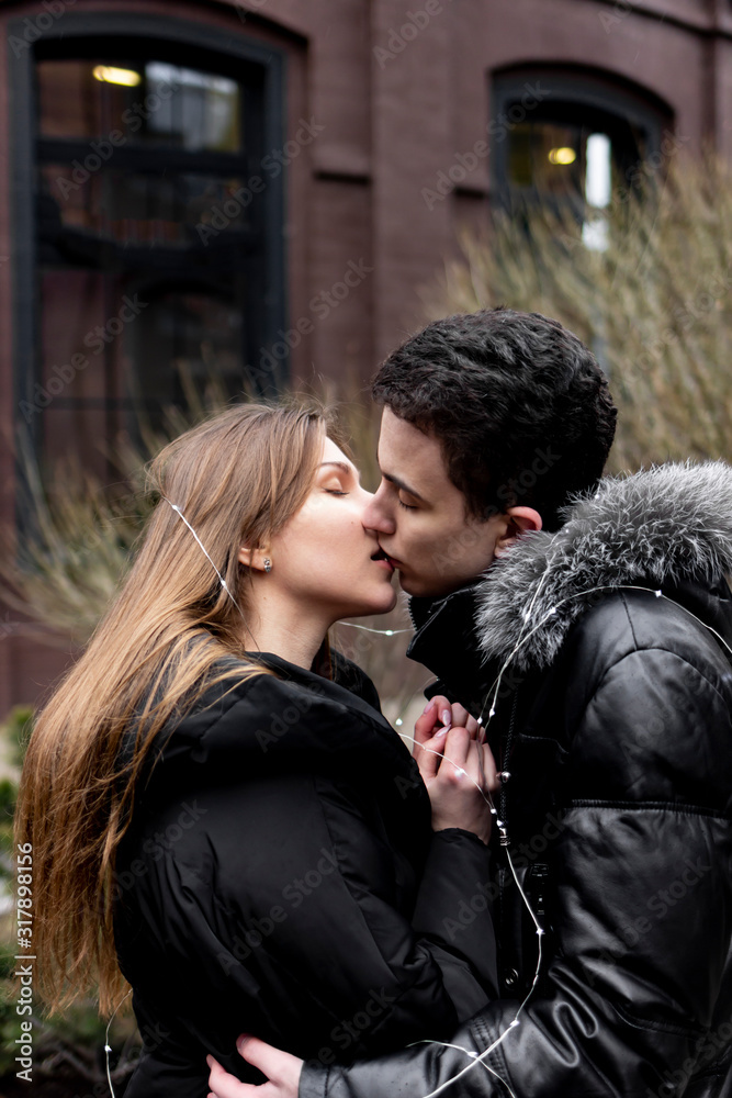 Happy young couple in love kiss on the street. Valentine's Day. Happy young couple in love kiss on the street. Valentine's Day.