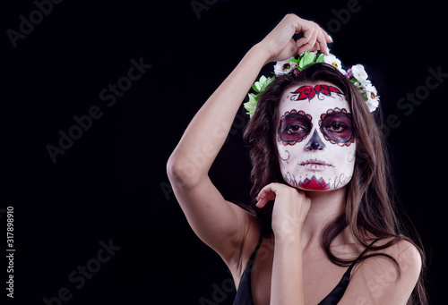 Young woman with sugar skull makeup. Dia de los muertos. Day of The Dead. Halloween costume and make-up. Portrait of Calavera Catrina