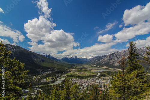 Lookout view of Banff town in Canada Alberta Rocky Mountains overlooking mountains with blue sky and clouds 