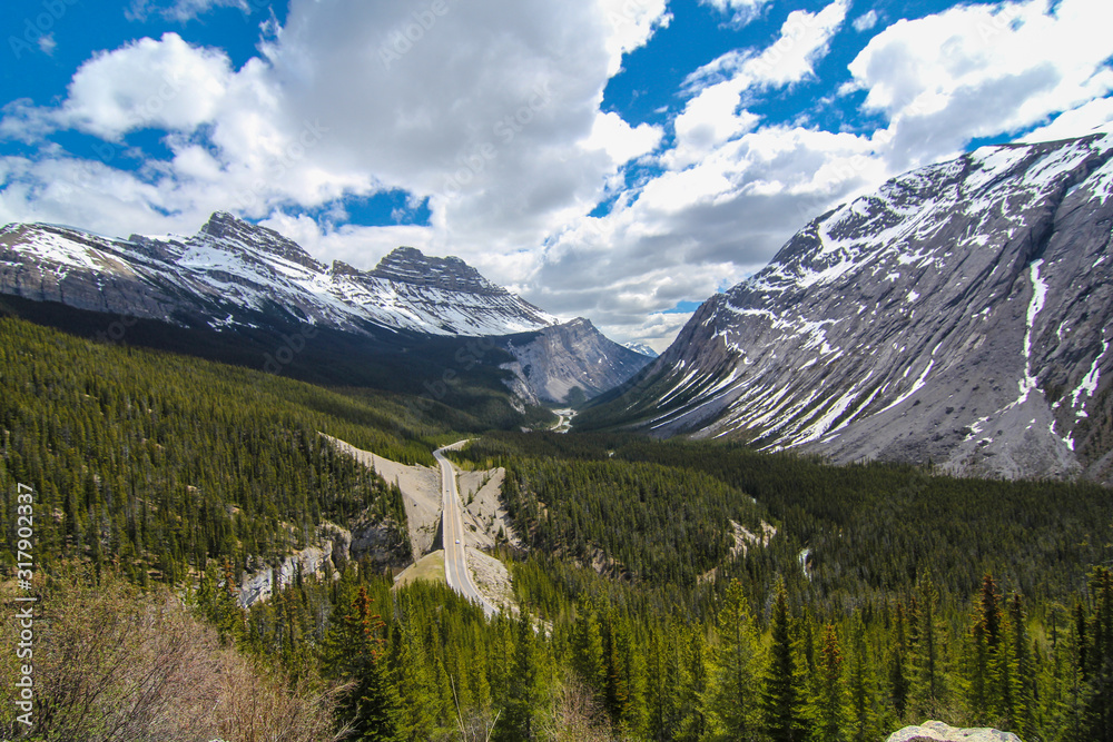 View of national park Banff Jasper road in between mountains scenic breathtaking view lookout car driving valley massive peaks 