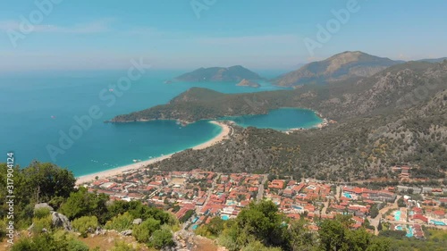 Aerial view of summer city near mountains and sea water. Flying above mountains. Drone shot