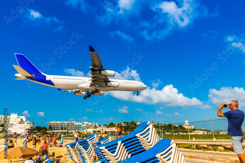 Landing of an airplane at Princess Juliana Airport from Maho Beach on the island of Saint Martin in the Caribbean photo