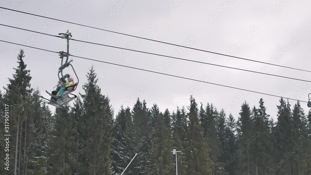 People skiing and snowboarding on snow slope in winter ski resort. Ski elevator on snow mountain. Winter activity on ski resort People skiing and snowboarding on snow slope in winter ski resort. Ski elevator on snow mountain. Winter activity on ski resort
