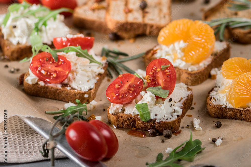 Mini canapes with cheese, tomatoes and tangerines