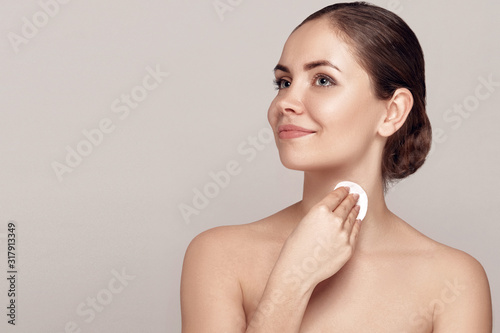 Beautiful young smiling woman with clean cotton pads. Facial treatment. Cosmetology, beauty and spa .Beauty skin care famale face. Expressive facial expressions. photo