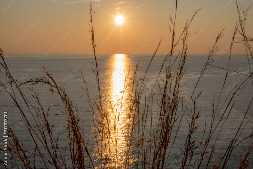 Golden sunrise sunset over the Adratic sea in Montenegro, view from the top of the Mogren Fortress in Budva.Quiet place. Relaxing scene.Calm sea water. Beautiful colors in the sky.