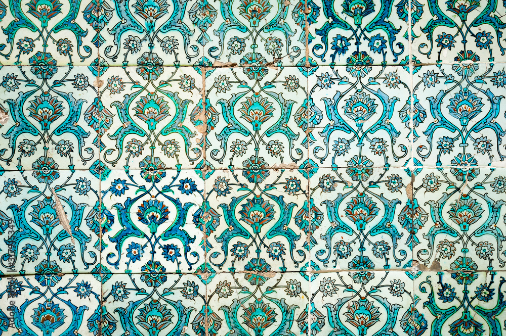 Medieval era glazed tile wall of intricate blue hand painted floral patterns in a Turkish Islamic mosque in Istanbul, Turkey dating back to 1459