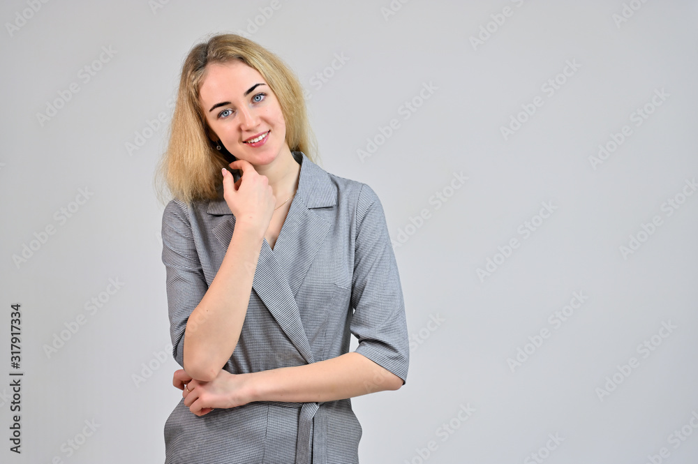 Model Standing directly in front of the camera in various poses. Portrait of a pretty cute smiling young blonde business woman with minimal makeup in a gray suit on a white background. Model Standing directly in front of the camera in various poses. Portrait of a pretty cute smiling young blonde business woman with minimal makeup in a gray suit on a white background.