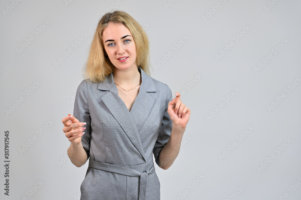 Model Standing directly in front of the camera in various poses. Portrait of a pretty cute smiling young blonde business woman with minimal makeup in a gray suit on a white background. Model Standing directly in front of the camera in various poses. Portrait of a pretty cute smiling young blonde business woman with minimal makeup in a gray suit on a white background.