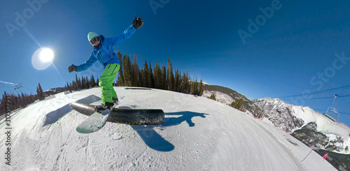 SELFIE Awesome action shot of a snowboarder sliding along a railing in snow park photo