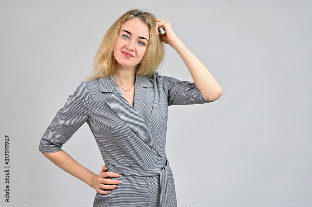 Portrait of a pretty cute smiling young blonde business woman with minimal makeup in a gray suit on a white background. Model Standing directly in front of the camera in various poses. Portrait of a pretty cute smiling young blonde business woman with minimal makeup in a gray suit on a white background. Model Standing directly in front of the camera in various poses.