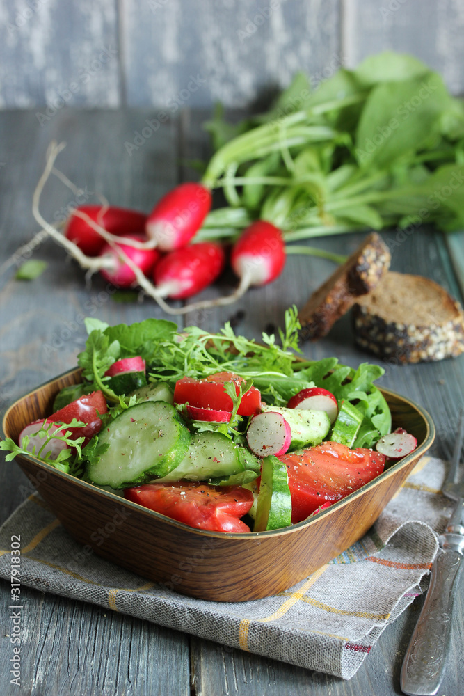 The concept of healthy kitchen. Salad of fresh herbs, radish, cucumber and tomatoes with oil on a lignt wooden background. Copy space, background image. The concept of healthy kitchen. Salad of fresh herbs, radish, cucumber and tomatoes with oil on a lignt wooden background. Copy space, background image.