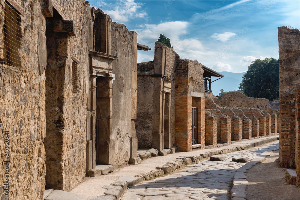 Obraz premium A street in the antique ruins of pompei, city destroyed by the vesuvius volcano eruption in Italy, site inscribed on the world list heritage of UNESCO