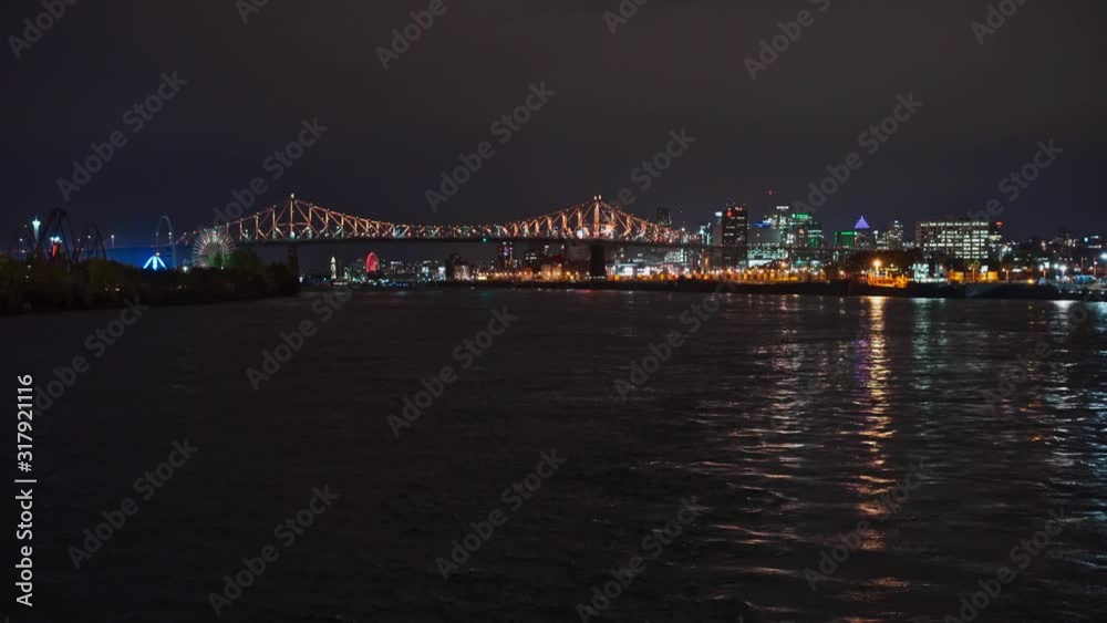 Beautifully illuminated night view of Jacques Cartier Bridge from Saint Lawrence River with Montreal city in the background. Beautifully illuminated night view of Jacques Cartier Bridge from Saint Lawrence River with Montreal city in the background.