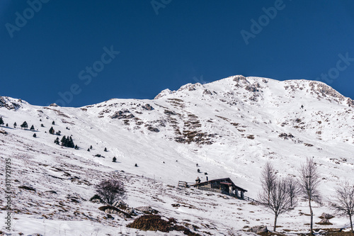 The snowy mountains, the woods and the mountain pastures during a fantastic winter day, near the town of Borno, Italy - December 2019.