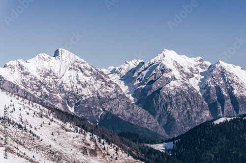The snowy mountains  the woods and the mountain pastures during a fantastic winter day  near the town of Borno  Italy - December 2019.