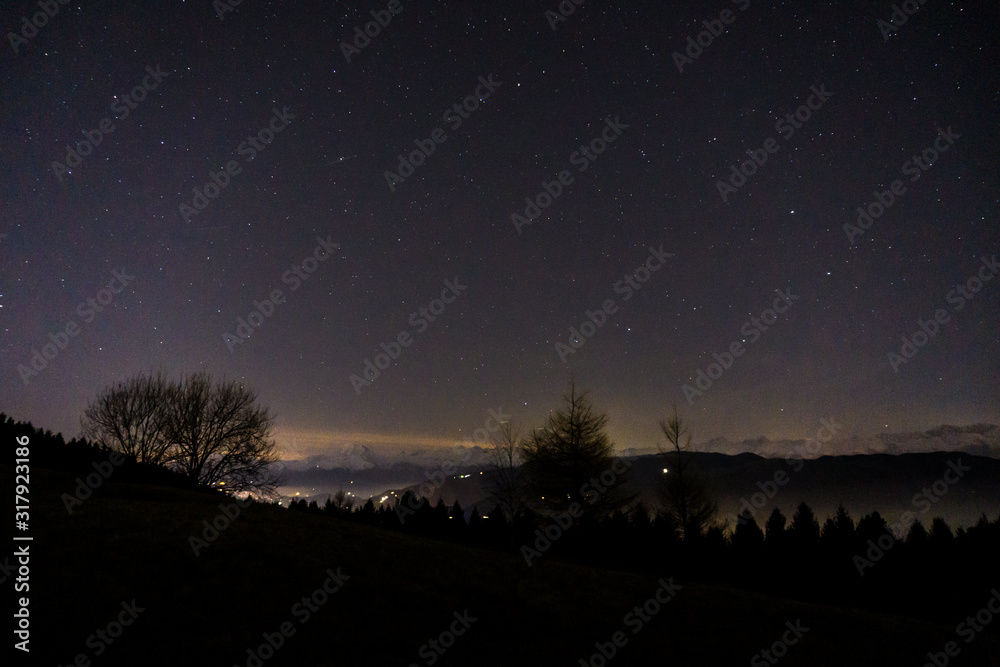 The view and landscape during a starry night, near the village of San Fermo, Lombardy, Italy - December 2019.