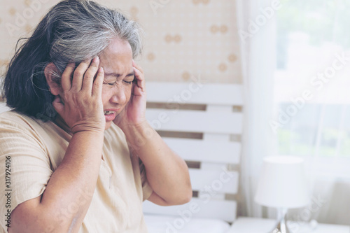 Elderly patients in bed, Asian senior woman patients headache hands on forehead - medical and healthcare concept