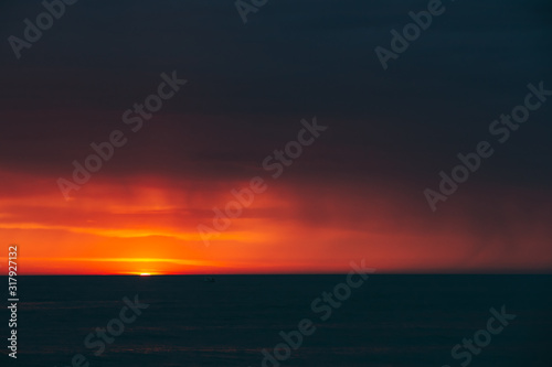Natural Colorful Sunset Sunrise Sky Over Sea After Storm Rain. Seascape With Shining Setting Sun On Sea Horizon