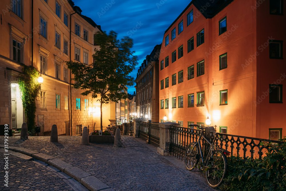 Fototapeta premium Stockholm, Sweden. Night View Of Traditional Stockholm Street. Residential Area, Cozy Street In Downtown. Osterlanggatan Street In Historical District Gamla Stan. Parked Bicycle Bike In European City
