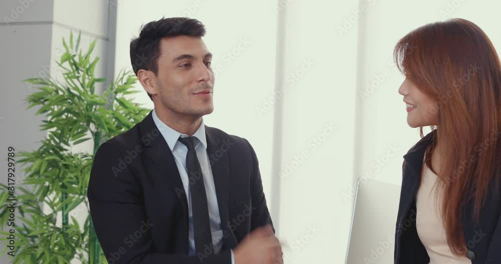 Panning scene video of handsome Caucasian businessman talking to a co-worker an Asian beautiful woman during their break. Panning scene video of handsome Caucasian businessman talking to a co-worker an Asian beautiful woman during their break.