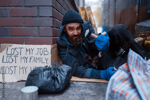 Photos Bearded beggar sleeping on city street