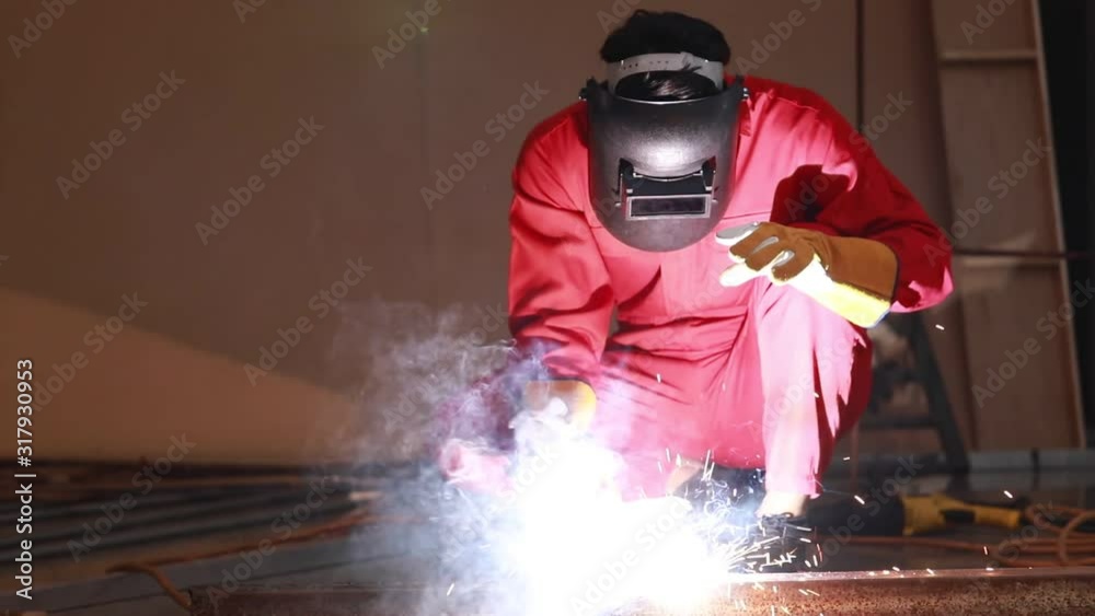 Close up scene video of a mechanic who is wearing a welding masked. He cutting metal with tools. Sparks and smoke spread all around. Close up scene video of a mechanic who is wearing a welding masked. He cutting metal with tools. Sparks and smoke spread all around.