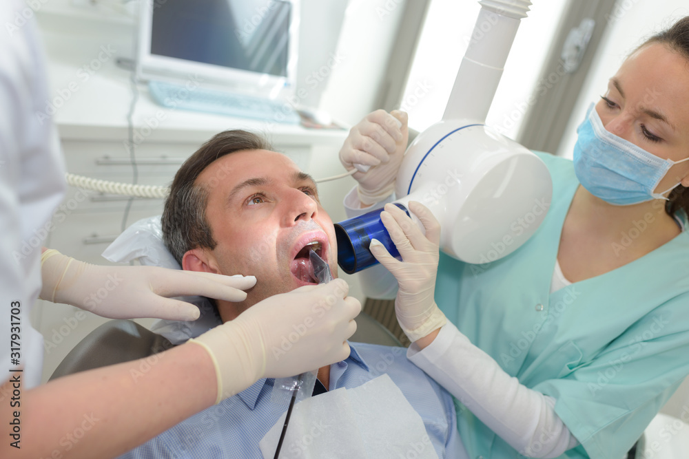dentist taking x-ray of patients teeth dentist taking x-ray of patients teeth