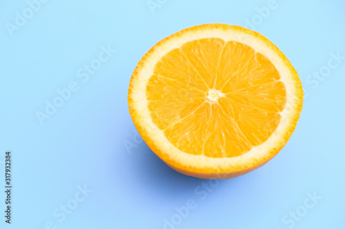 Slice of fresh orange isolated on blue background view